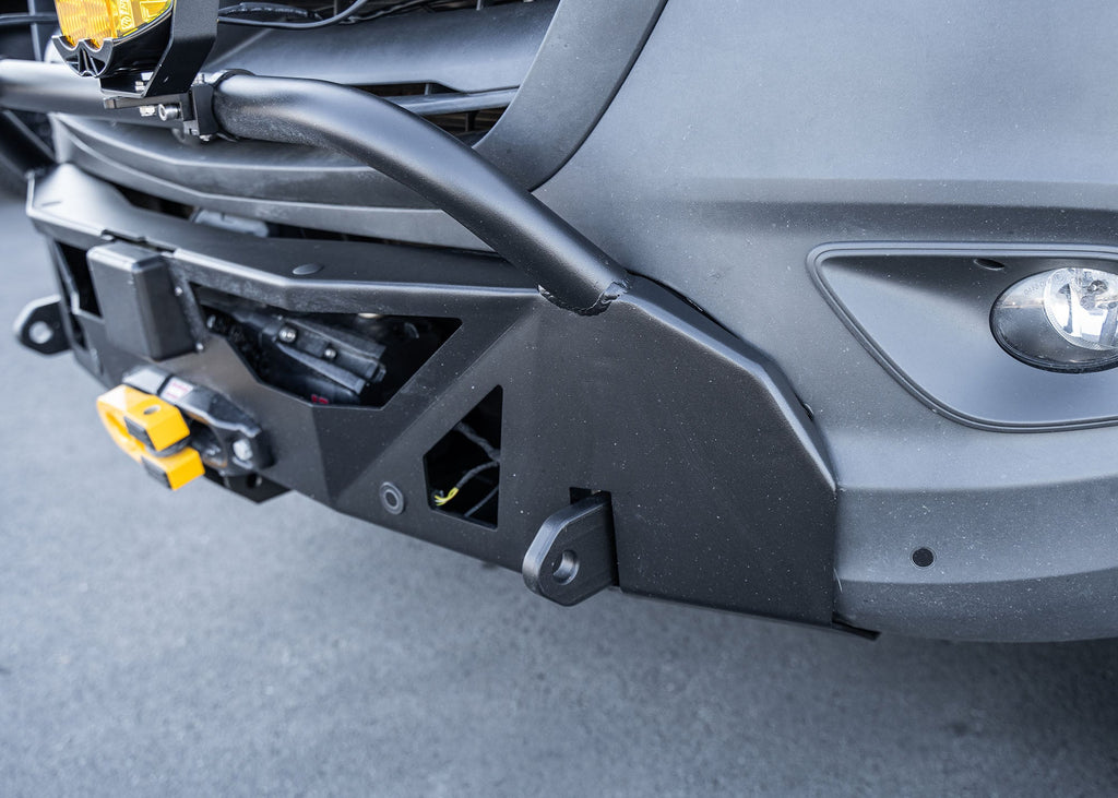 Close-up of the driver-side profile of a Mercedes-Benz Sprinter van showcasing the ROAMBUILT LoPro Front Bumper, featuring a lightweight aluminum shell, integrated bull bar, and a seamless design that adds only 3 inches of bulk while aligning precisely with the van‚Äôs body lines.