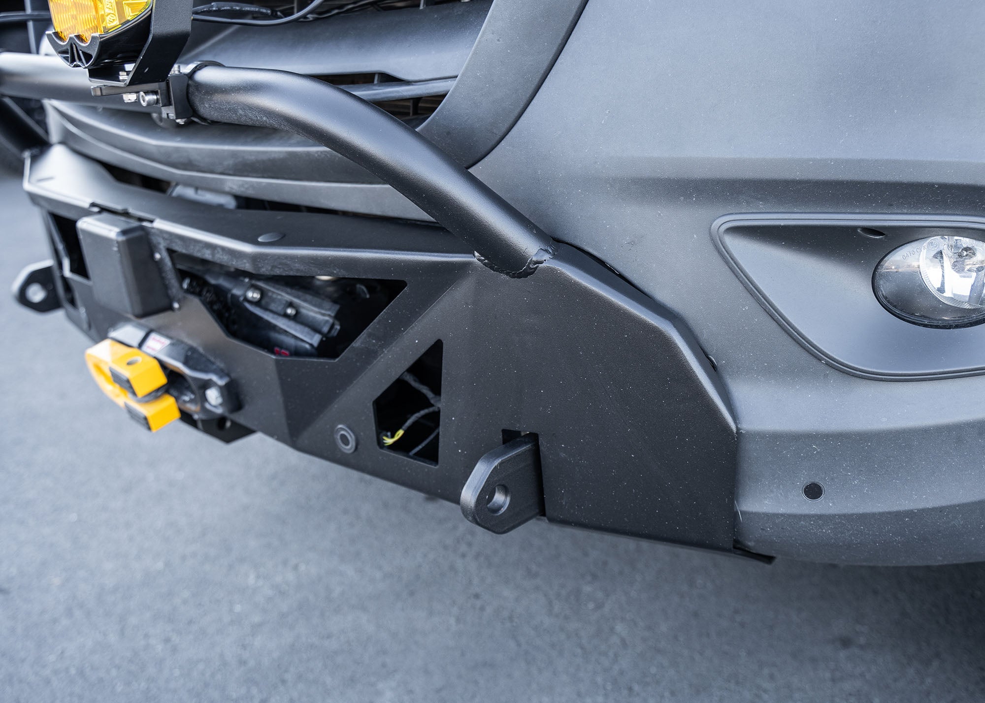 Close-up of the driver-side profile of a Mercedes-Benz Sprinter van showcasing the ROAMBUILT LoPro Front Bumper, featuring a lightweight aluminum shell, integrated bull bar, and a seamless design that adds only 3 inches of bulk while aligning precisely with the van‚Äôs body lines.